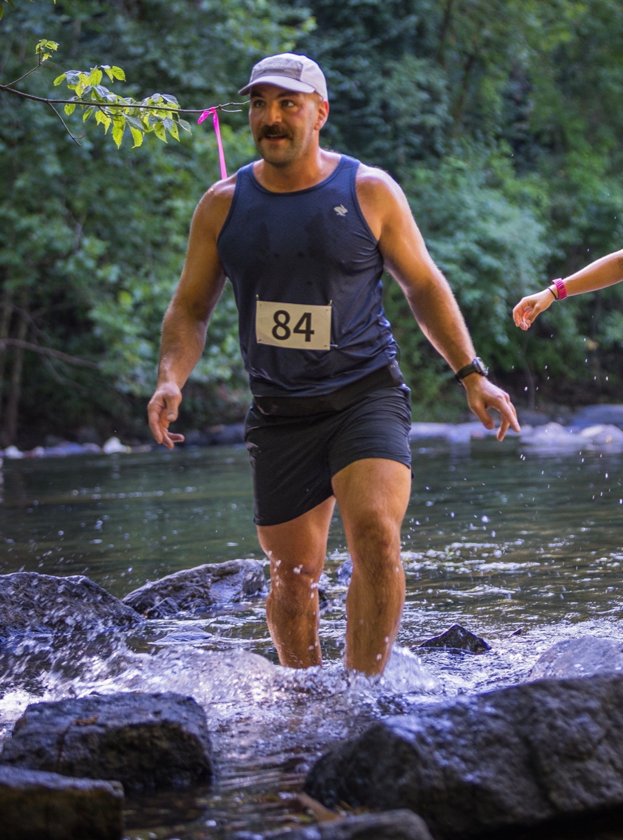 Trail running through a creek crossing at a race